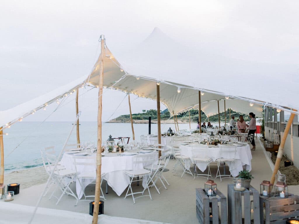 Une élégante réception de mariage en bord de mer, organisée par By Mademoiselle C, mettant en valeur un cadre romantique et sophistiqué. Ce lieu exceptionnel, avec sa tente blanche illuminée, crée l'atmosphère parfaite pour une célébration grandiose. Idéal pour un mariage sur mesure dans des destinations prisées comme la Provence, la Côte d'Azur et la Corse, cet événement unique incarne le luxe et le raffinement. Les tables soigneusement dressées, entour